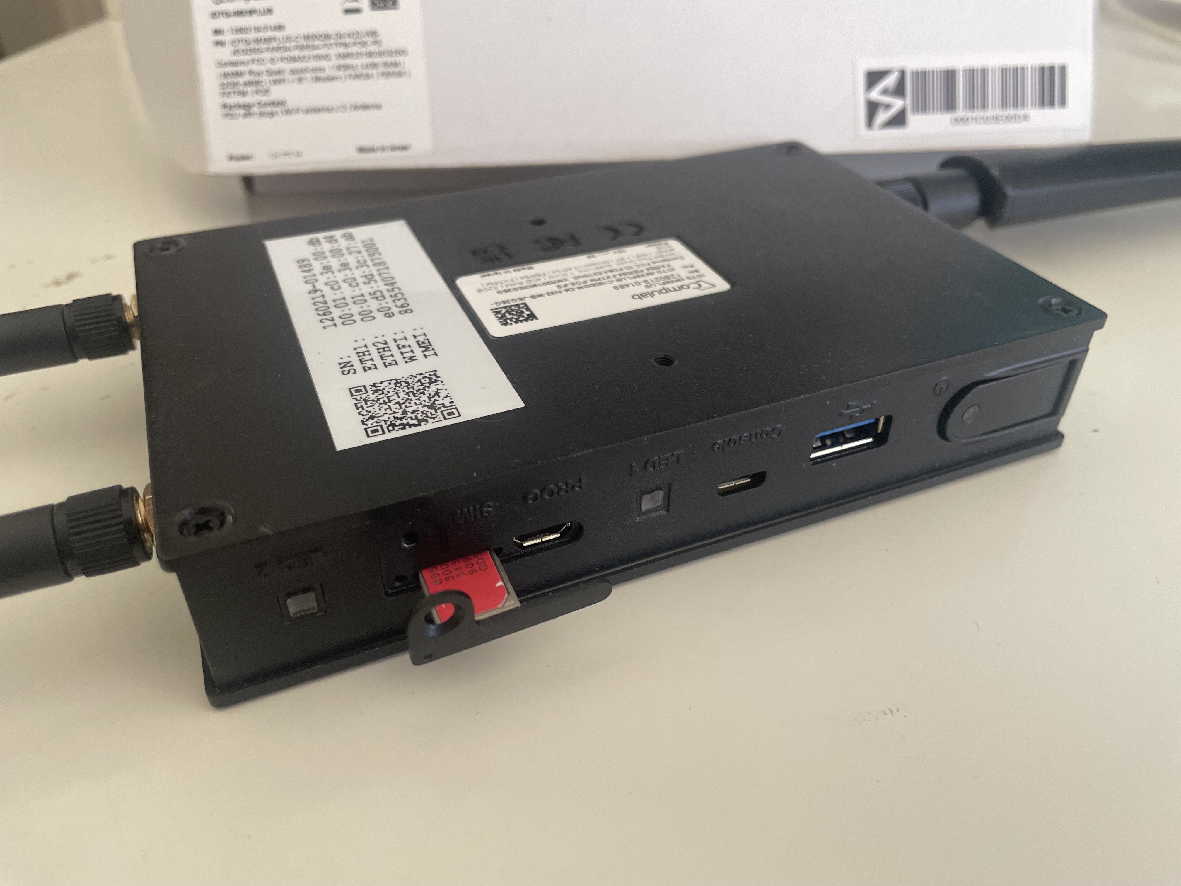 Inserting the SIM card on its tray into the Edge Controller, held upside down